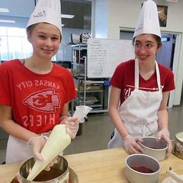 two teen girls practice making home made ice cream sandwiches